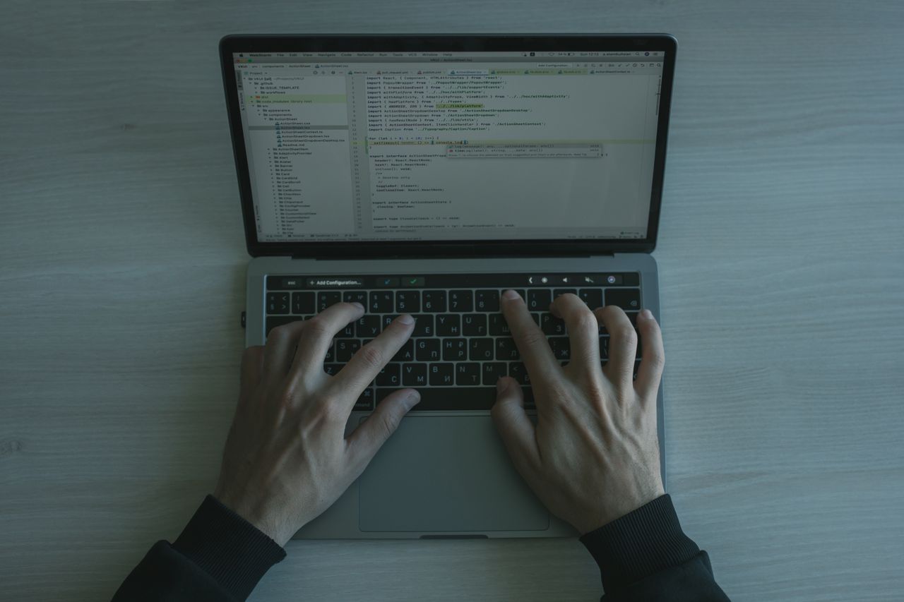 Services Close-up view of a programmer coding on a laptop, showcasing modern software development.